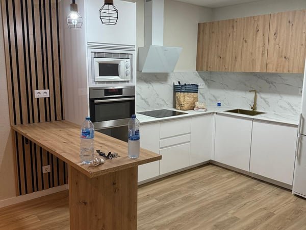 Cocina moderna con barra y muebles de madera